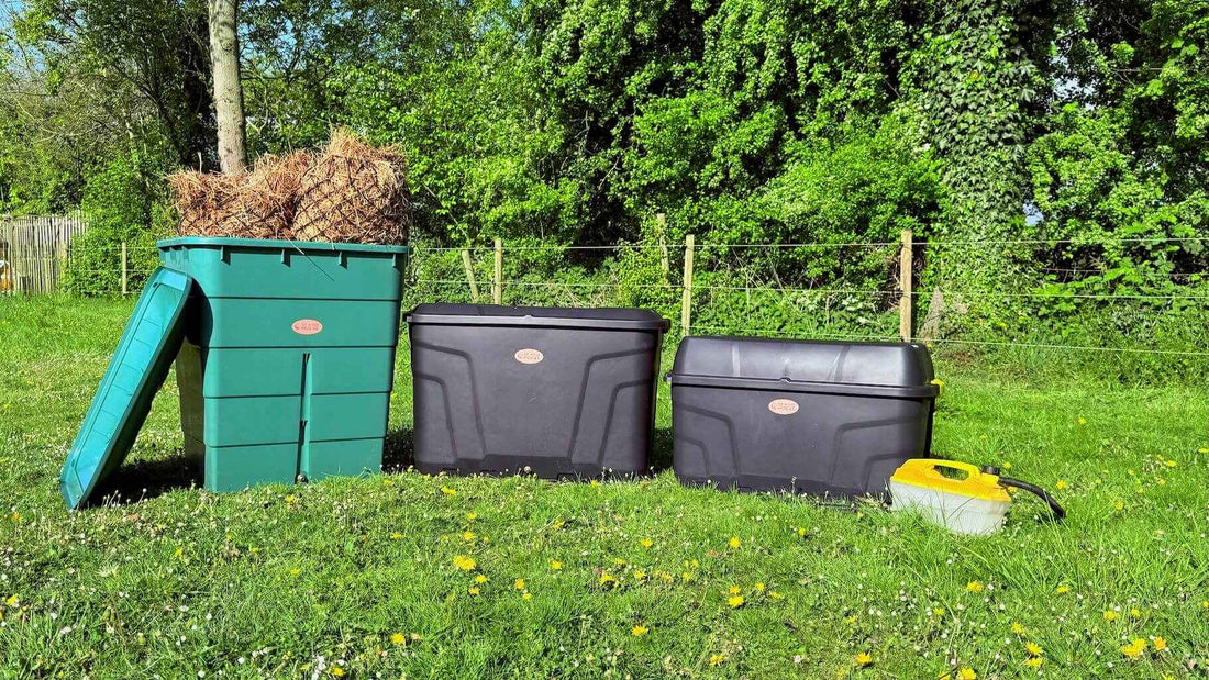 Drie hooistomer modellen met hooi op grasveld.