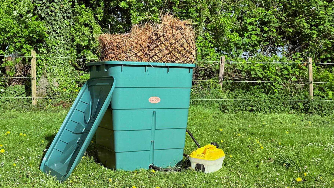 Grote groene hooistomer met hooi in tuin.