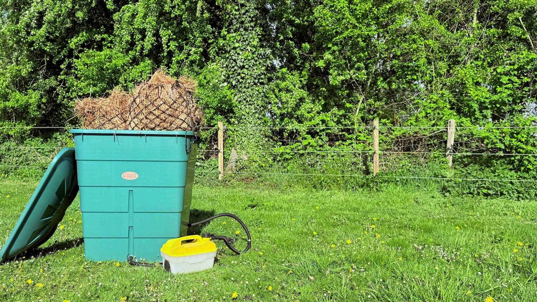 Grote groene hooistomer met hooi in grasveld