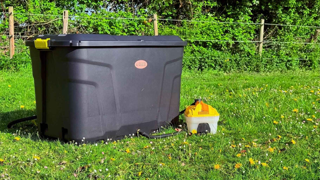 Hooistomer De Trog buiten gebruikt, hooi in de bak terwijl de stoomslang naast de trog ligt op het gras.