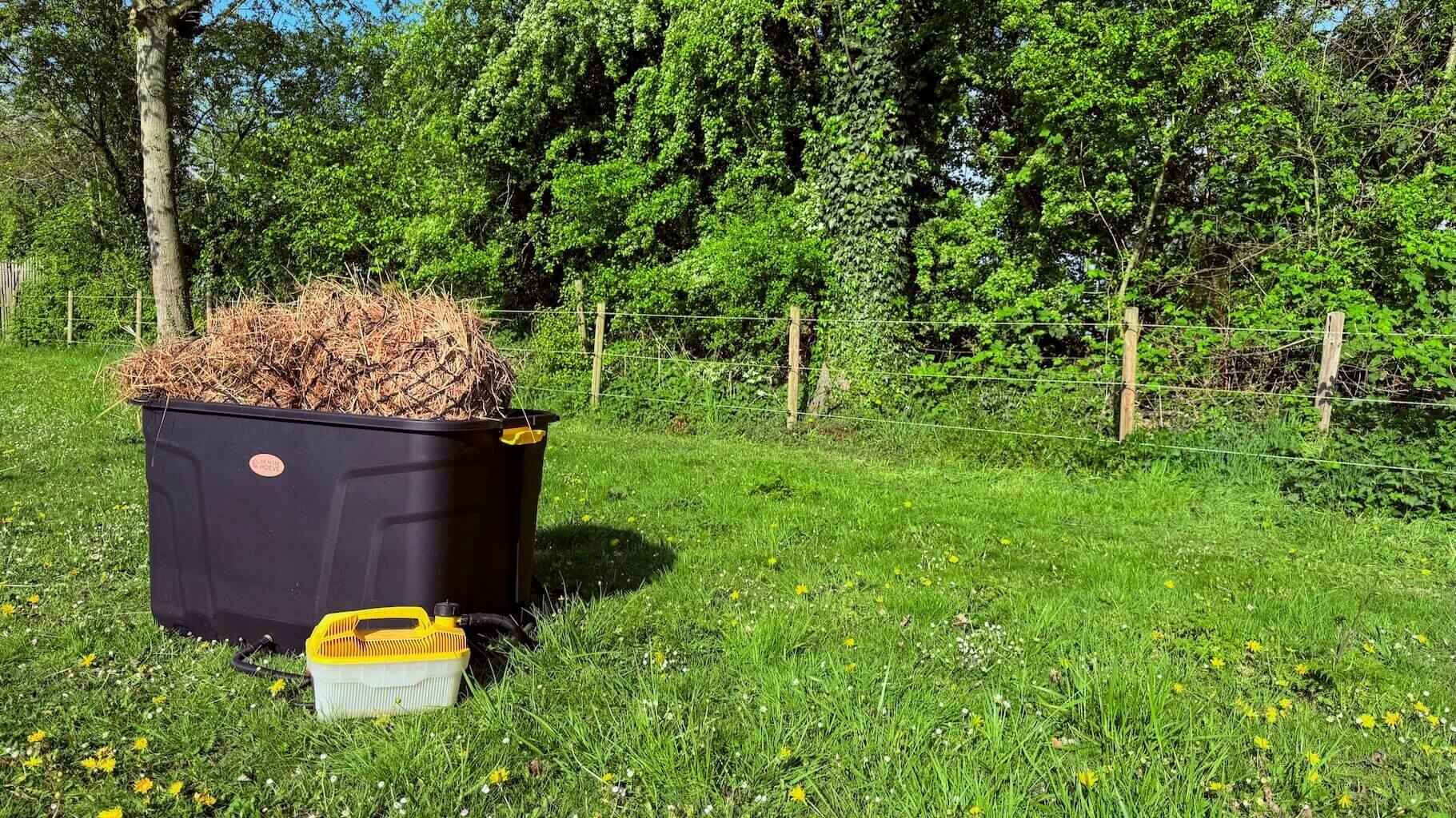 De Trog hooistomer op het gras, klaar om hooi te stomen voor paarden in de wei.