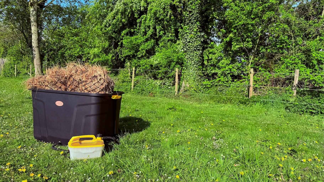 De Trog hooistomer op het gras, klaar om hooi te stomen voor paarden in de wei.