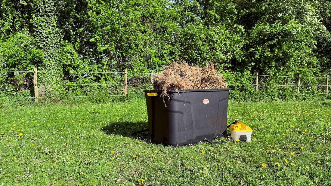 De Trog hooistomer buiten in het gras, gevuld met hooi en aangesloten op het stoomapparaat.