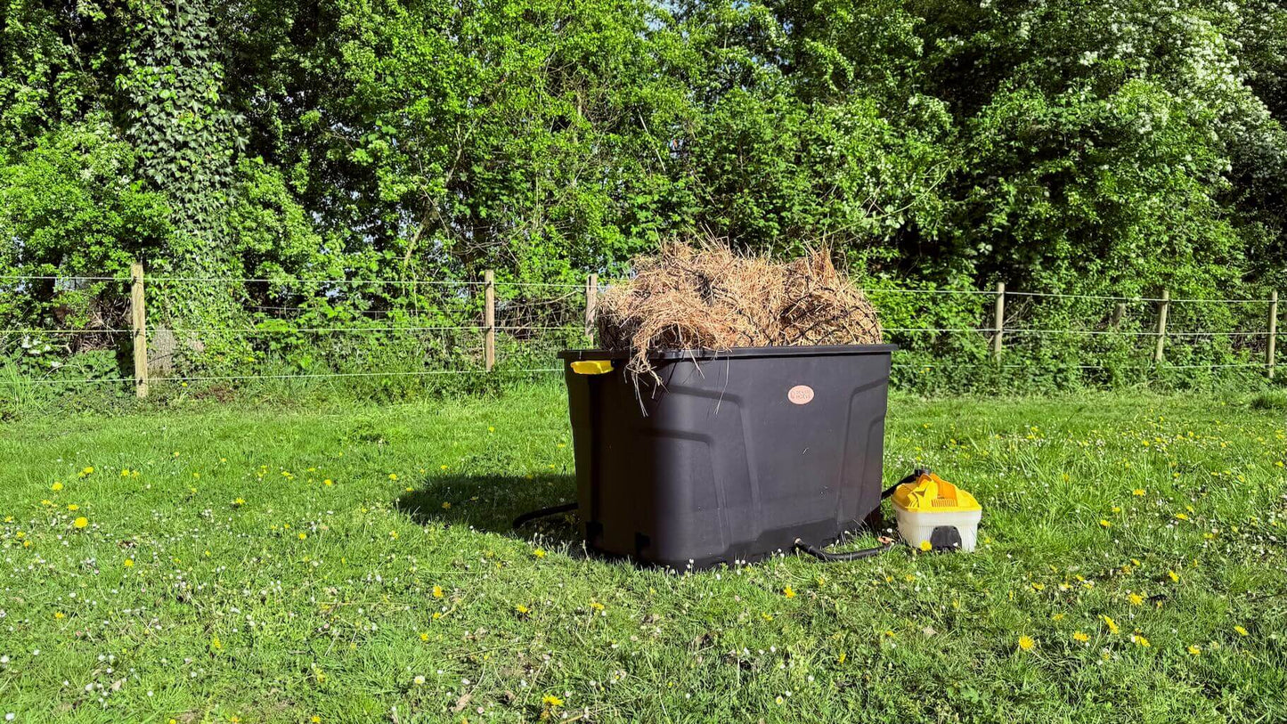 De Trog hooistomer buiten in het gras, gevuld met hooi en aangesloten op het stoomapparaat.