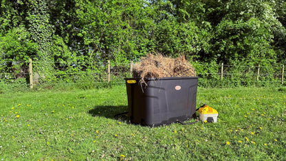 De Trog hooistomer buiten in het gras, gevuld met hooi en aangesloten op het stoomapparaat.