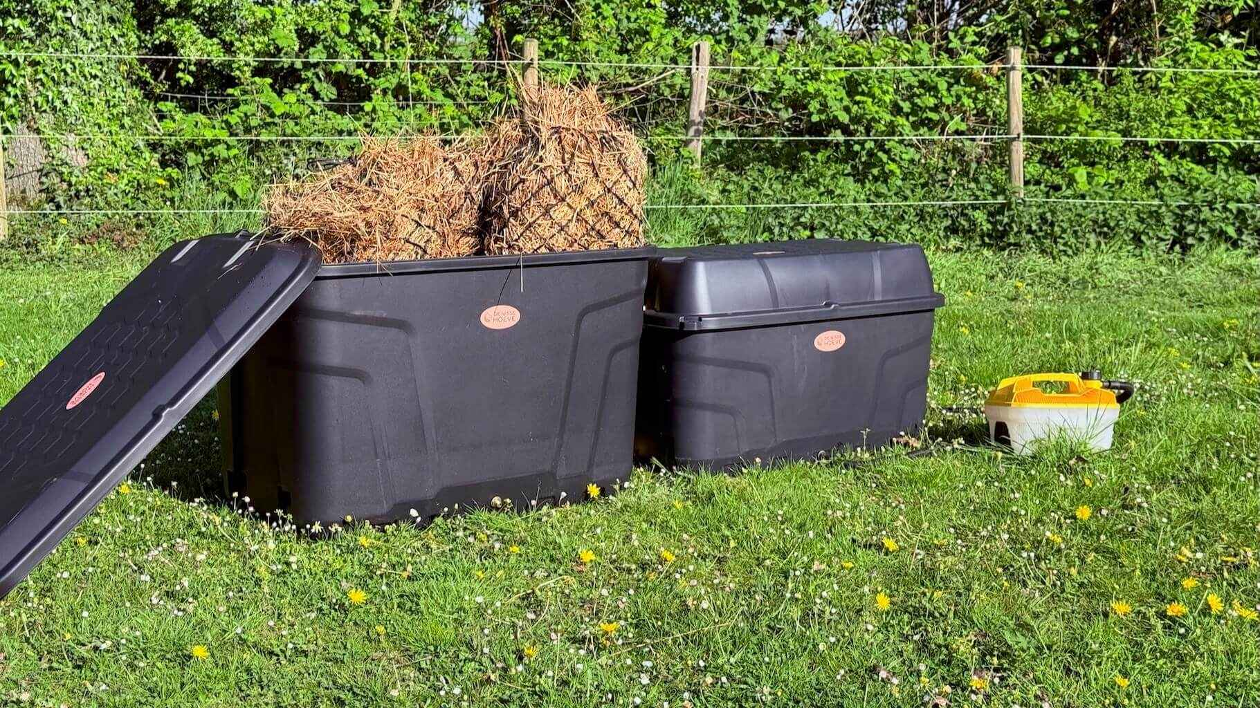 De Trog en de Krui hooistomer op het gras in de wei, gevuld met hooi en aangesloten met de stoomslang.