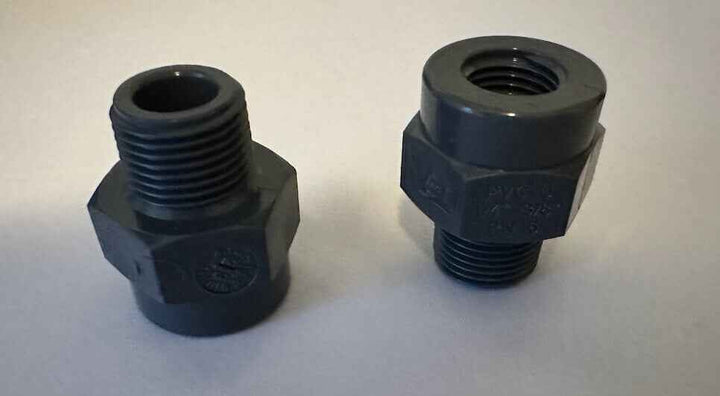 Twee zwarte kunststof schroefdraadkoppelingen