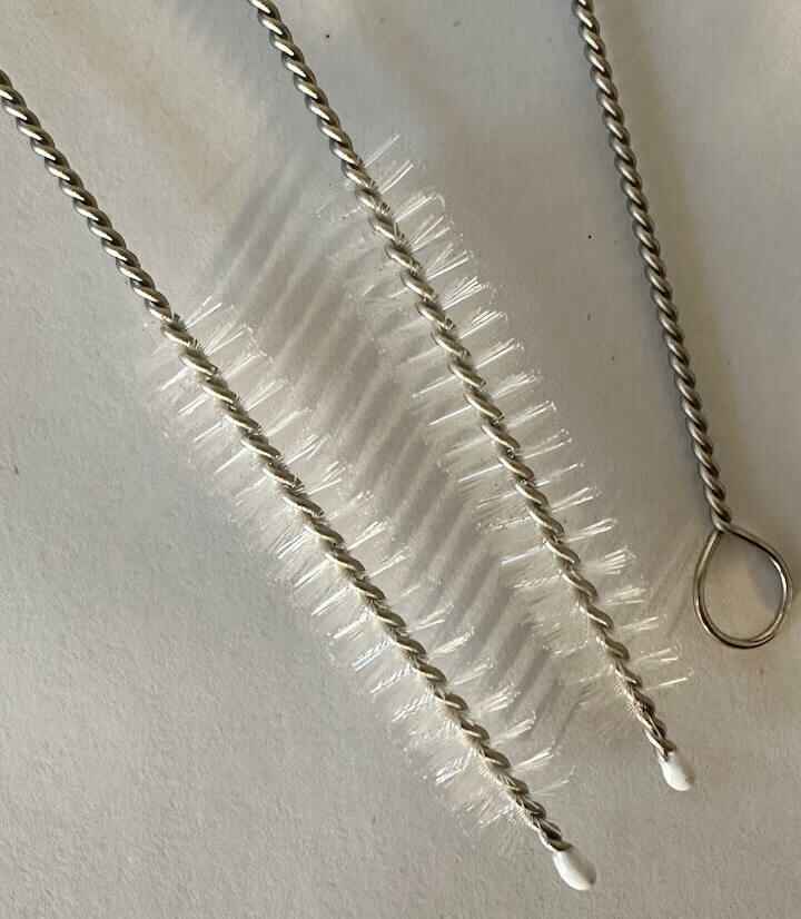 Twee metalen schoonmaakborstels op witte achtergrond.