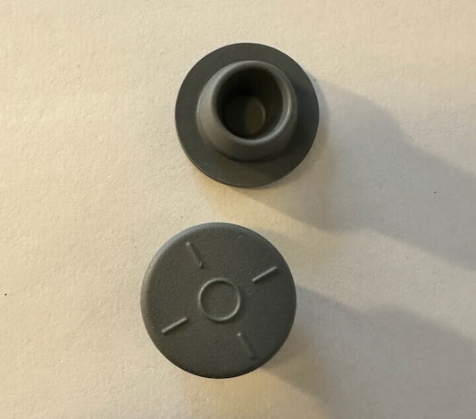Grijze LEGO-onderdelen op een witte achtergrond.